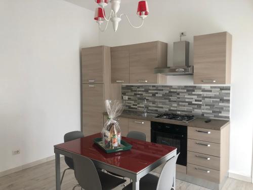 巴列塔Casa Vacanze De Nittis的厨房配有红色桌子和炉灶