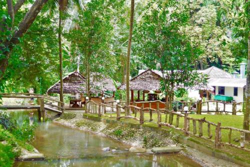 湄宏颂The Creek Garden Resort Huainamrin ห้วยนำ้ริน的河边的木栅,有房子