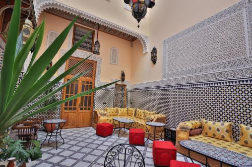 非斯Riad Diamant De Fes的大厅,配有沙发和桌子,还有盆栽植物