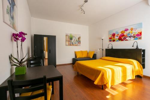 罗马Holiday rental St Peter's area的一间卧室配有一张黄色的床和一张桌子