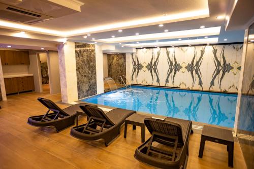 伊斯坦布尔Hamitbey Hotel Yenikapı的一个带椅子和桌子的大型游泳池