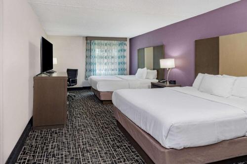 查塔努加查塔努加拉金塔旅馆及套房 - 东岭的酒店客房设有两张床和紫色的墙壁。