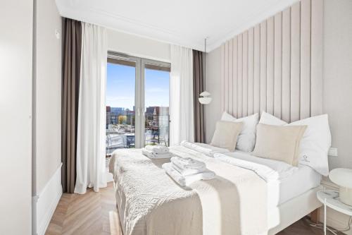 格但斯克GREAT Grano Residence的白色的卧室设有床和大窗户