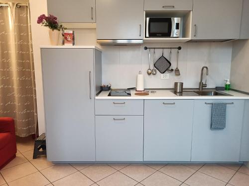 博洛尼亚Appartamenti Borghetto San Donato 105的小厨房配有白色橱柜和水槽