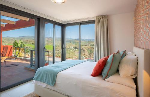 萨洛夫雷Las Terrazas Villa 3的一间卧室设有一张床和一个大型玻璃窗