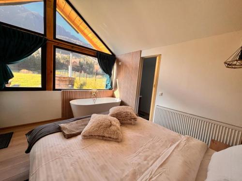 泽尔内什蒂View Piatra Craiului的卧室配有床、浴缸和窗户。