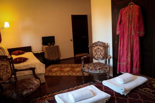 安塔利亚哈德里安那斯酒店的客厅配有床和椅子以及电视