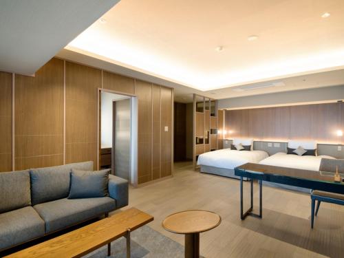 热海Atami Sekaie的酒店客房,设有两张床和一张沙发