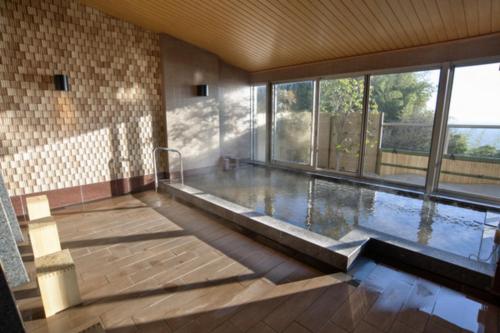 热海Atami Sekaie的一座大型游泳池,位于一座带大窗户的建筑内