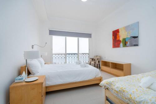 拉斯阿尔卡麦Stunning 2BD Sea View Apartment Private Beach Access的一间卧室设有两张床和窗户。
