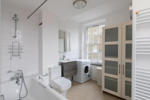 伦敦Flat near Lord's Cricket Ground的浴室配有卫生间水槽和洗衣机。