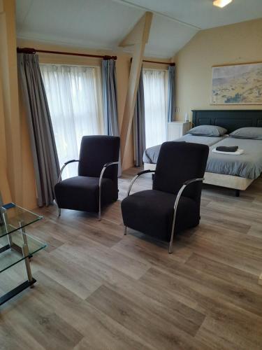 旧比尔特宰尔Logement 'De witte klok'的酒店客房带两把椅子和一张床