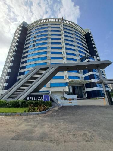 苏拉特Rajhans Belliza , Hotel apartment units的一座高大的蓝色建筑,前面有楼梯