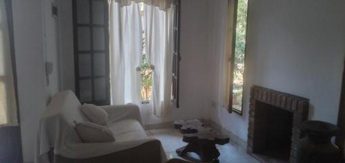 伊瓜苏港Posada Enki的客厅配有两把白色椅子和壁炉