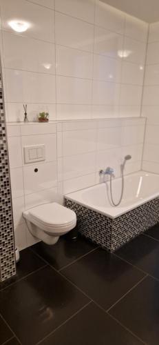 不来梅港Homey Apartments Harbor Suite - Parking Two Bathrooms Netflix Sea view的白色的浴室设有卫生间和浴缸。