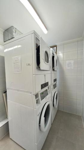 普孔Departamento Edificio Aqua Pucón的洗衣房配有2台洗衣机和烘干机
