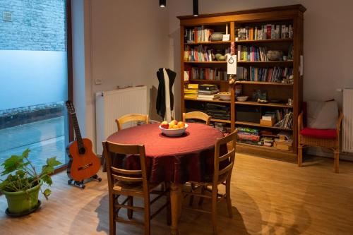 奥德纳尔德Bed en boek的餐桌,配有一碗水果和吉他