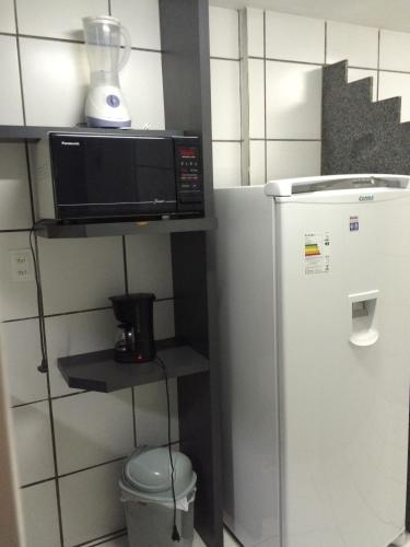 累西腓公园路服务式公寓的冰箱旁的架子上有一个微波炉