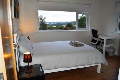 福克斯福德Twin Lake View - Bungalow in Pontoon的卧室配有白色的床、书桌和窗户。