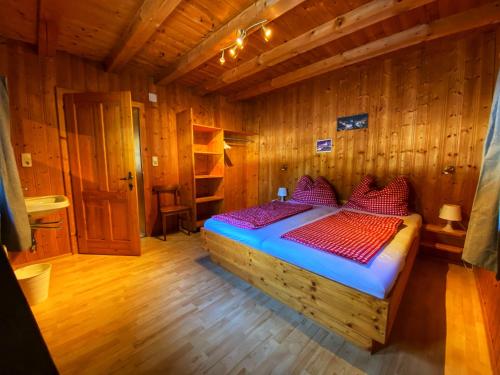 施图拜河谷新施蒂夫特Ferienhaus Falbeson的木制客房内的一间卧室,配有一张床