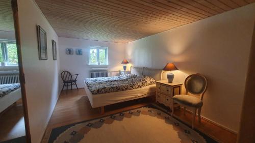 克内贝尔Rolsø Retreat - the apartment的一间小卧室,配有一张床和一把椅子