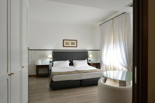 阿格里真托德拉瓦莱酒店的一间卧室配有一张床和一把椅子