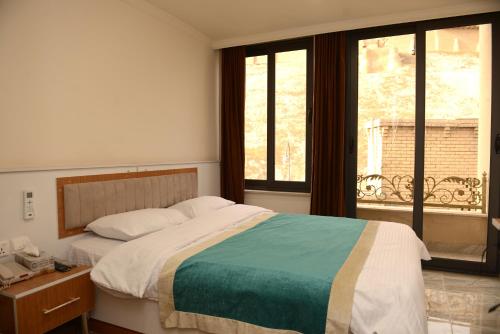 埃尔比勒Syros Hotel Erbil City Center的一间卧室设有一张大床和一个窗户。