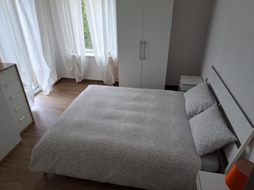 皮耶韦迪卡多雷VILLA ESTER -Residenze dolomitiche-的一间卧室配有一张床、一个梳妆台和一扇窗户。