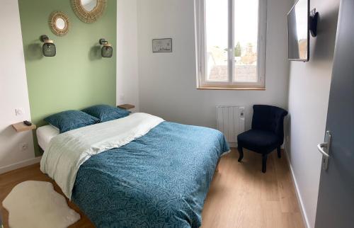 蓬托尔松Gîte mont-blan的一间卧室配有一张带蓝色被子和椅子的床