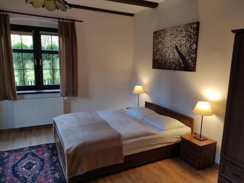 斯克拉斯卡波伦巴Pod Chybotkiem的一间卧室配有一张床、两盏灯和一个窗户。