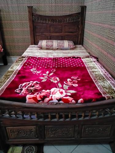 拉合尔Five Giants Lahore Homestay的床上有红毯