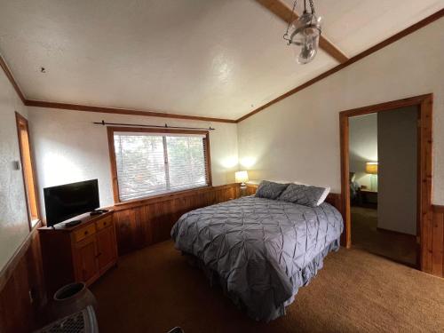 熔岩温泉村Adventures Vacation Rentals的一间卧室配有一张床和一台电视