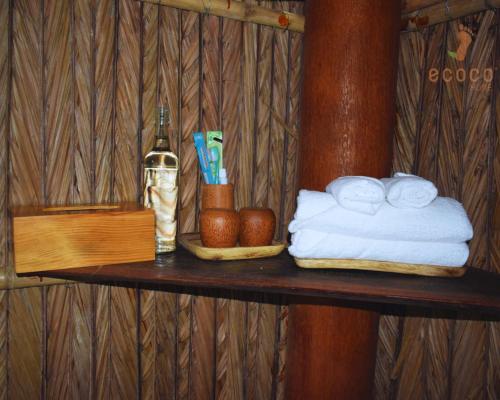 槟知Ecoco Homestay Mekong的一个带毛巾和一瓶葡萄酒的木架