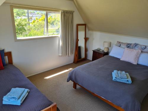纳尔逊Seaside Tahuna的一间卧室设有两张床和窗户。