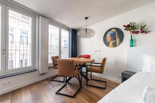 布雷达Stylish apartments in the heart of Breda city center的一间带桌椅和一张床的用餐室