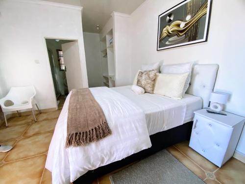 帕拉佩Ranzi Court的卧室配有一张白色大床和椅子