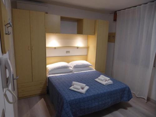 里米尼Affittacamere Vittoria的一间卧室配有一张床,上面有两条毛巾