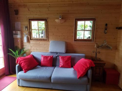 GagnyNormandy cottage的客房内的蓝色沙发,配有红色枕头