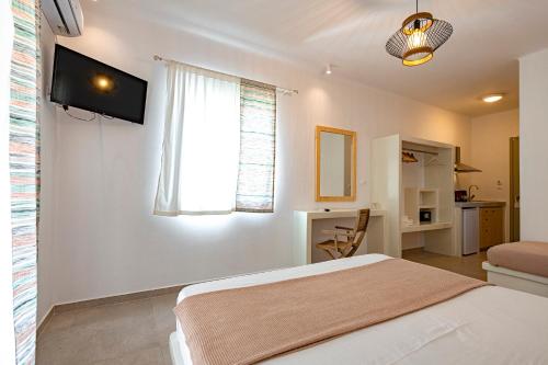 基莫洛斯岛Alisea Resort的白色的卧室设有床和窗户