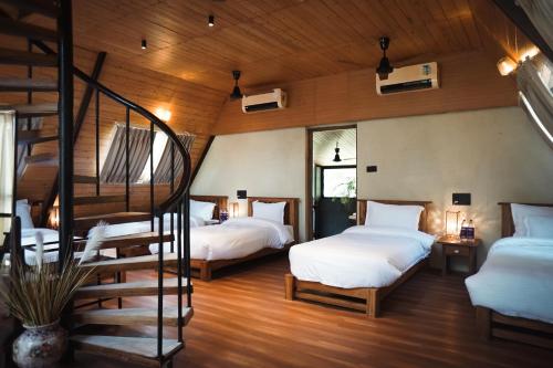 KhawāsaLA SELVA Resort, Pench National Park的一间带两张床的卧室和螺旋楼梯