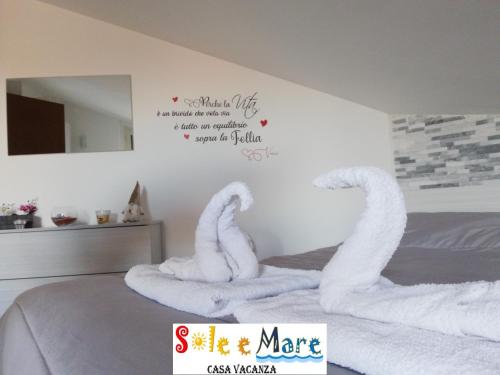 圣萨尔沃SOLE e MARE Luxury Home的卧室配有用毛巾制成的天鹅床