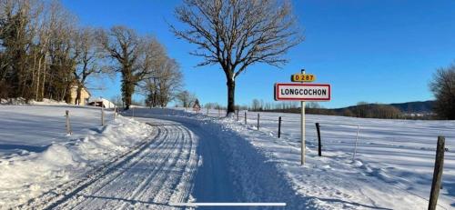 LongcochonLe gite de Longcochon的一条有雪覆盖的道路,上面有一条标志,上面写着后送