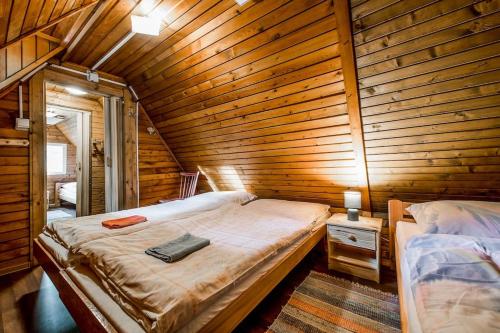 LučivnáOld Fashioned Cottage in Lopusna dolina near High Tatras的卧室配有木墙内的一张床