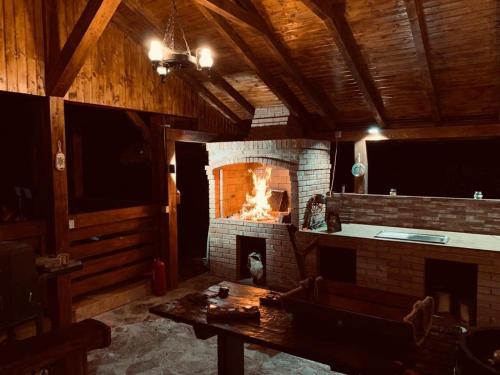 阿尔杰什河畔库尔泰亚Dorul Pescarului的客厅设有砖砌壁炉和桌子
