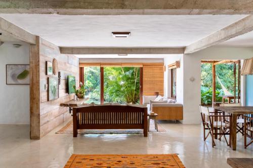 托兰克索Casa Laranjeiras, Rio da Barra beach, Trancoso的客厅配有长凳和桌子