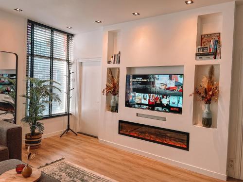 哈莱姆Coolest Apartment in Haarlem City - close to Beach and Amsterdam的客厅设有壁炉和平面电视。