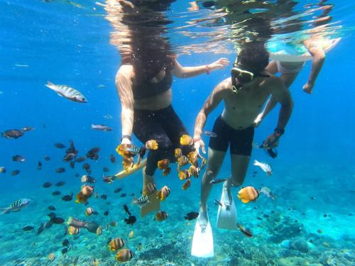 珀尼达岛Kubu Penida Villa的两个人在海洋里用塑料瓶潜水