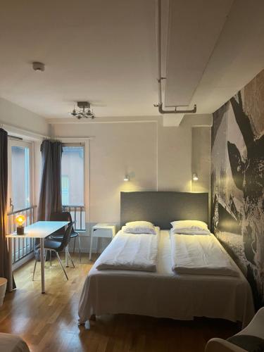 卑尔根City Hostel Bergen的一间卧室配有一张床铺和一张桌子,还有一间用餐室