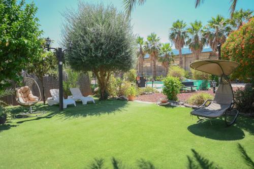 谢莫纳城Suites in the Galilee的庭院设有草坪、椅子和雨伞