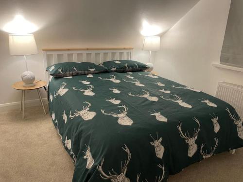 KentStylish & Spacious 2 Storey, 3 Bed Apartment的一张带绿毯的床,上面有鹿
